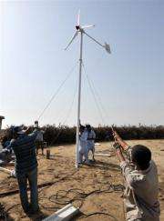 Pakistani technicians install a wind turbine on the island of Kharochhan