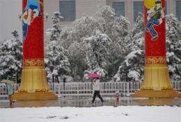 Pedestrians make their way across the snow in Tian'anmen Square