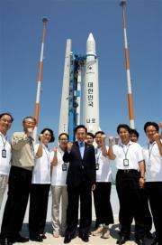 President Lee Myung-Bak poses in front of the KSLV-1 rocket