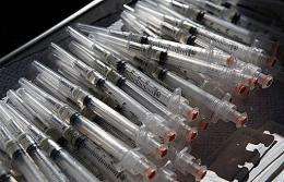 Syringes with influenza virus vaccine sitting on a tray