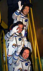 Top-bottom: Soichi Noguchi, Timothy J. Creamer and Oleg Kotov wave before boarding a Soyuz TMA-17 spacecraft