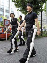 Two men and a woman were testing robotic suits designed to give mobility to the injured and disabled