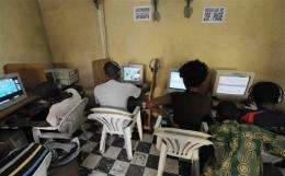 Young people browse the Internet in a cybercafe in Abidjan