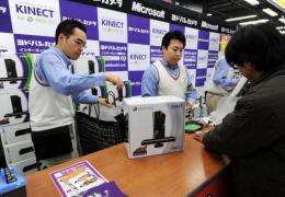 A Japanese customer (R) purchases the Microsoft Xbox 360 Kinect in Tokyo