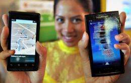 A model displays smartphones with Google's mobile operating system Android in Jakarta