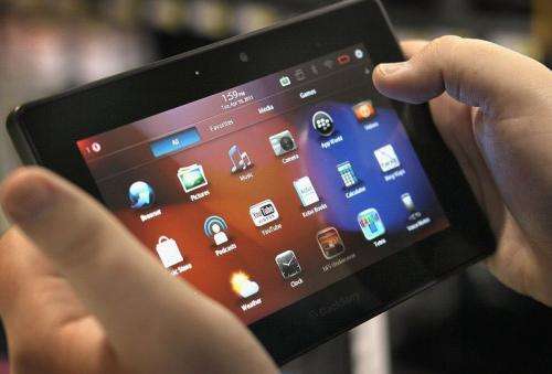 An employee demonstrates a Blackberry Playbook tablet