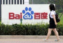 A woman walks past the logo of Baidu at its headquarters in Beijing