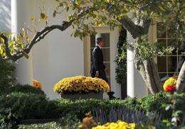 Barack Obama walks to the Oval Office as he returns to the White House