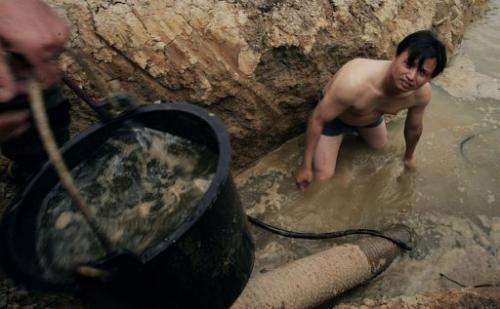 Chinese farmers dig a new well at their farm in Huangpi, central China's Hubei province