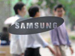 South Korean men walk past a Samsung logo in Seoul