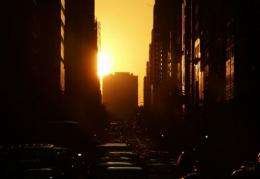 The sun sets over the west side of New York City, known as Manhattanhenge, a term coined by an astrophysicist