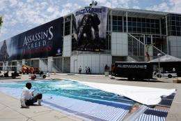 Workers hang banners in preparation for the E3 Expo