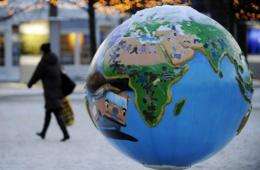 A woman walks past a globe exhibition about combatting global warming and climate change in Copenhagen in 2009