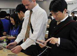 Customers check a tablet PC in a store in Tokyo