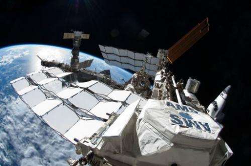 The International Space Station with Space Shuttle Atlantis docked on the right and a Russian Soyuz on the far left