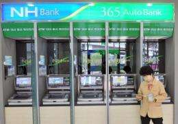 A bank customer is seen in front of a series of ATMs in Seoul