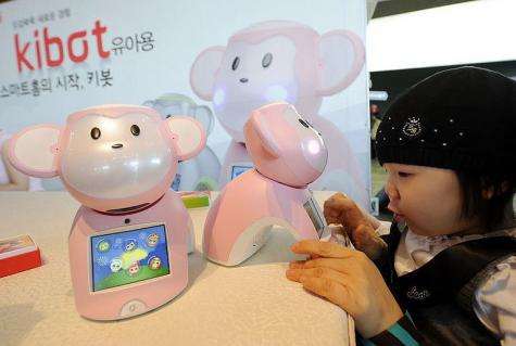 A child plays with a robot entitled "Kibot"