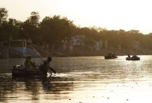 A couple collect refuse floating on the Yamuna River in New Delhi in June