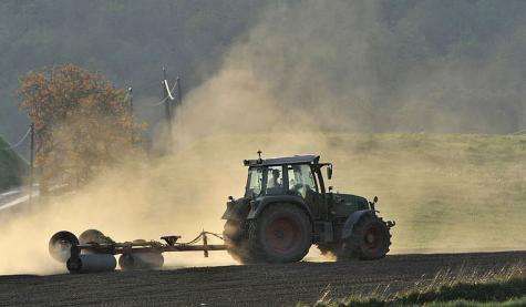 A farmer works on a field in his tractor