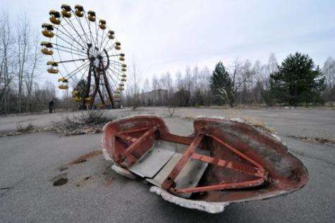 A ferris wheel and an abandoned leisure boat are pictured in a park in the ghost city of Pripyat, near Chernobyl