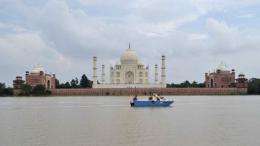 Agra police officials inspect the water level of the Yamuna river as it passes the Taj Mahal