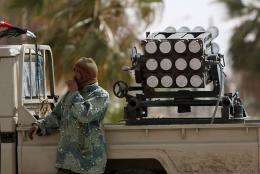 A Libyan rebel stands near a rocket launcher in the western gate of Ajdabiya