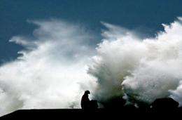 A local resident holds an umbrella while a giant wave hits the shore in Taiwan in 2002