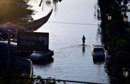 A man wades the flooded neighbourhood of Rangsit district on the outskirts of Bangkok