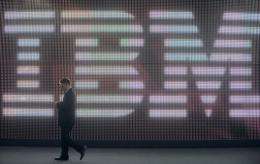 A man walks past the IBM logo