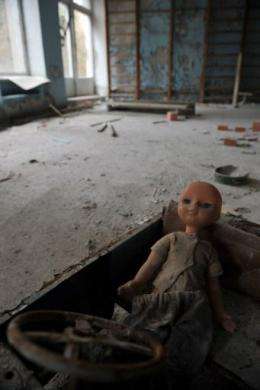 An abandoned plastic doll sits in a child's car at a kindergarden in the ghost town of Pripyat