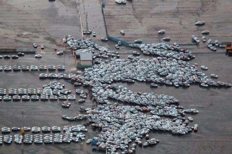 An aerial shot shows vehicles ready for shipping being carried by a tsunami tidal wave at Hitachinaka city in Japan