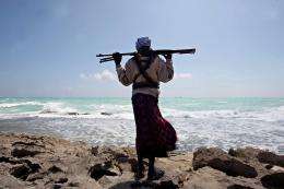 An armed Somali pirate stands along the coastline of Hobyo town in northeastern Somalia in 2010