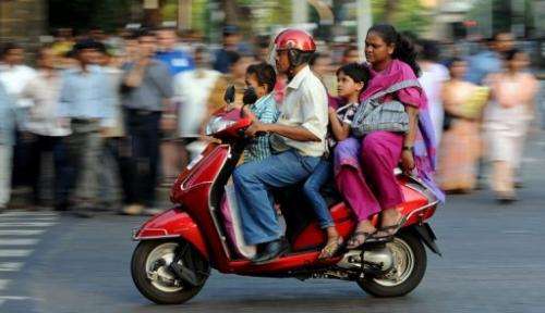 An Indian family travelling on a scooter in the commercial district of Fort in Mumbai