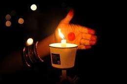 An Indian women holds a lighted candle during an Earth Hour campaign in Mumbai