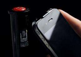 An iPhone in front of a bottle-top silver bubble seal used to foil fraudsters and reassure consumers of authenticity