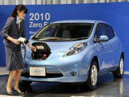 A Nissan employee demonstrates how to plug in the "Leaf"