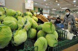 A shopper looks at vegetables at a Tokyo supermarket after a government warning on abnormal radiation levels