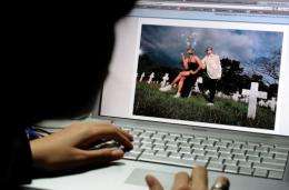 A student views an online photo album on the social networking site Facebook