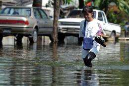 A Thai woman walks through floodwaters in Bangkok on Friday