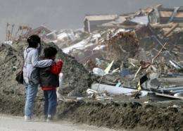 A tsunami survivor and her son visit their disaster-damaged home