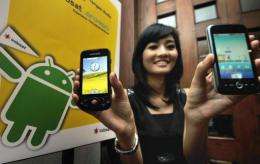 A woman at at launch in Jakarta last year displays smartphones using Google's Android operating system