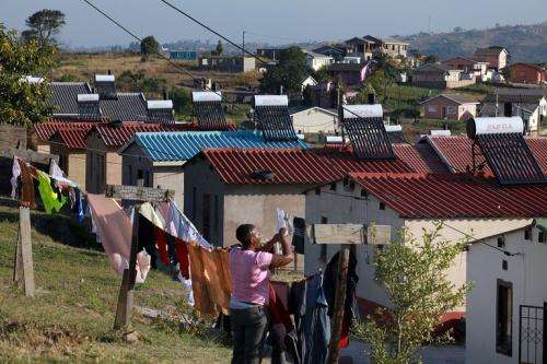 A woman hangs her laundry in the township of Demat where power company Eskom installed solar heaters on roofs