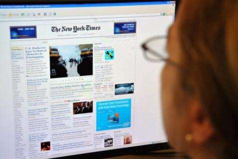A woman reads the front page of the New York Times on the Internet, in Washington, DC