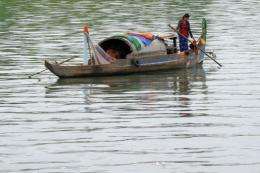 A woman rows a boat along the Mekong river in Phnom Penh