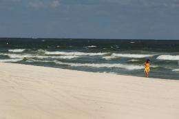 A woman walks along the deserted beach in Gulf Shores, Alabama, in 2010