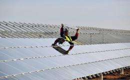 A worker installs panels at a photovoltaic power plant in Crucey-Villages, France