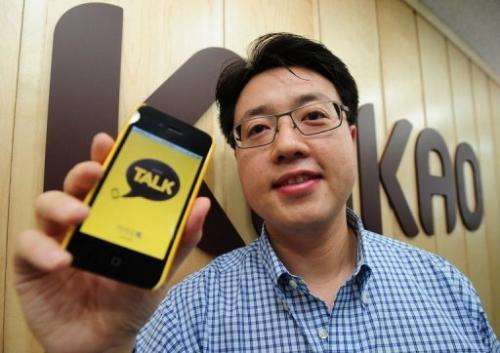 CEO of Kakao Talk Lee Jae-Beom poses in front of KAKAO Company's logo in Seoul