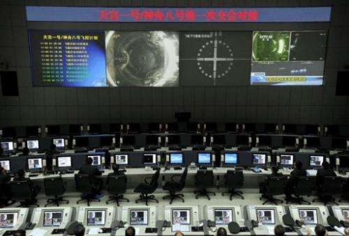 Chinese scientists monitor the docking of the Tiangong-1 space lab module and the Shenzhou VIII spacecraft