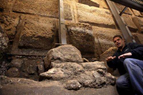 Eli Shukron of the Israel Antiquities Authority kneels inside a ritual bath exposed beneath the Western Wall