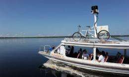 Google team members sail a boat with a 360-degree camera system mounted on a Trike on its top